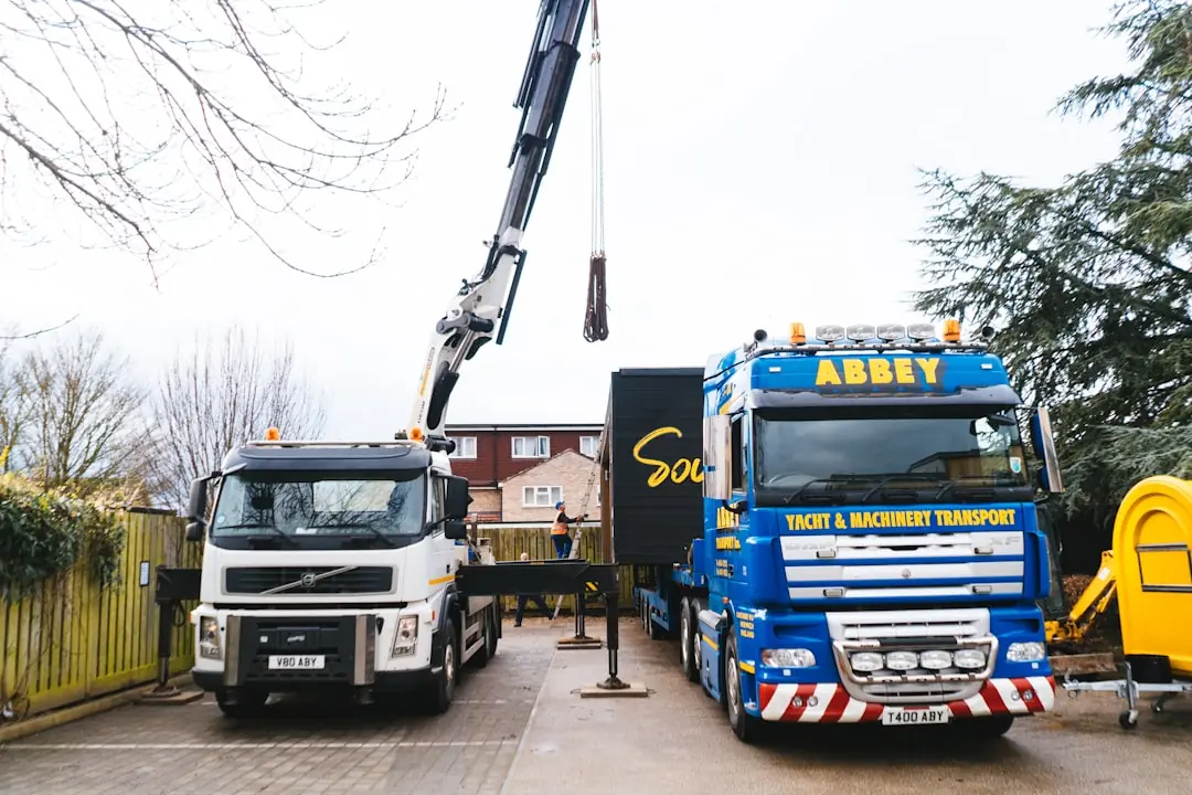 Nákladní auto s hydraulickou rukou před rodinným domem při dopravě vířivky